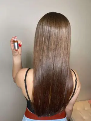 Cabelo castanho cheio de brilho e maciez após o uso de uma das ampolas do kit de cronograma capilar da DYUSAR